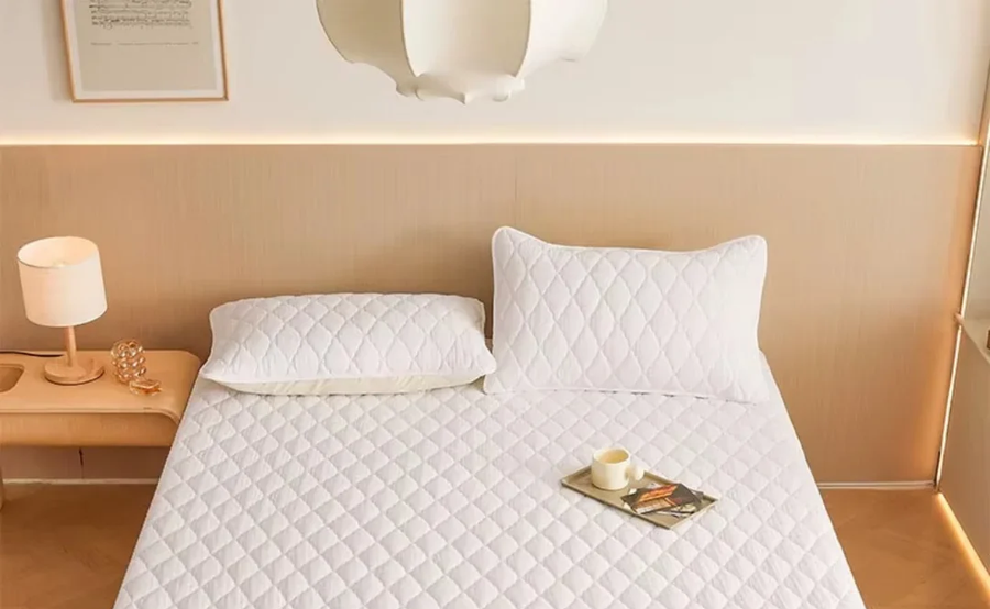 Protector de colchón blanco puesto en una cama