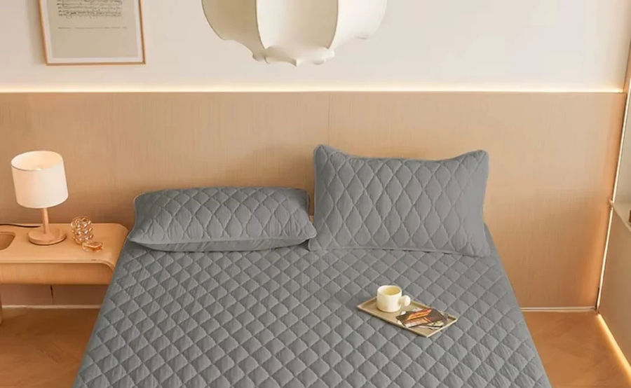 Protector de colchón gris puesto en una cama