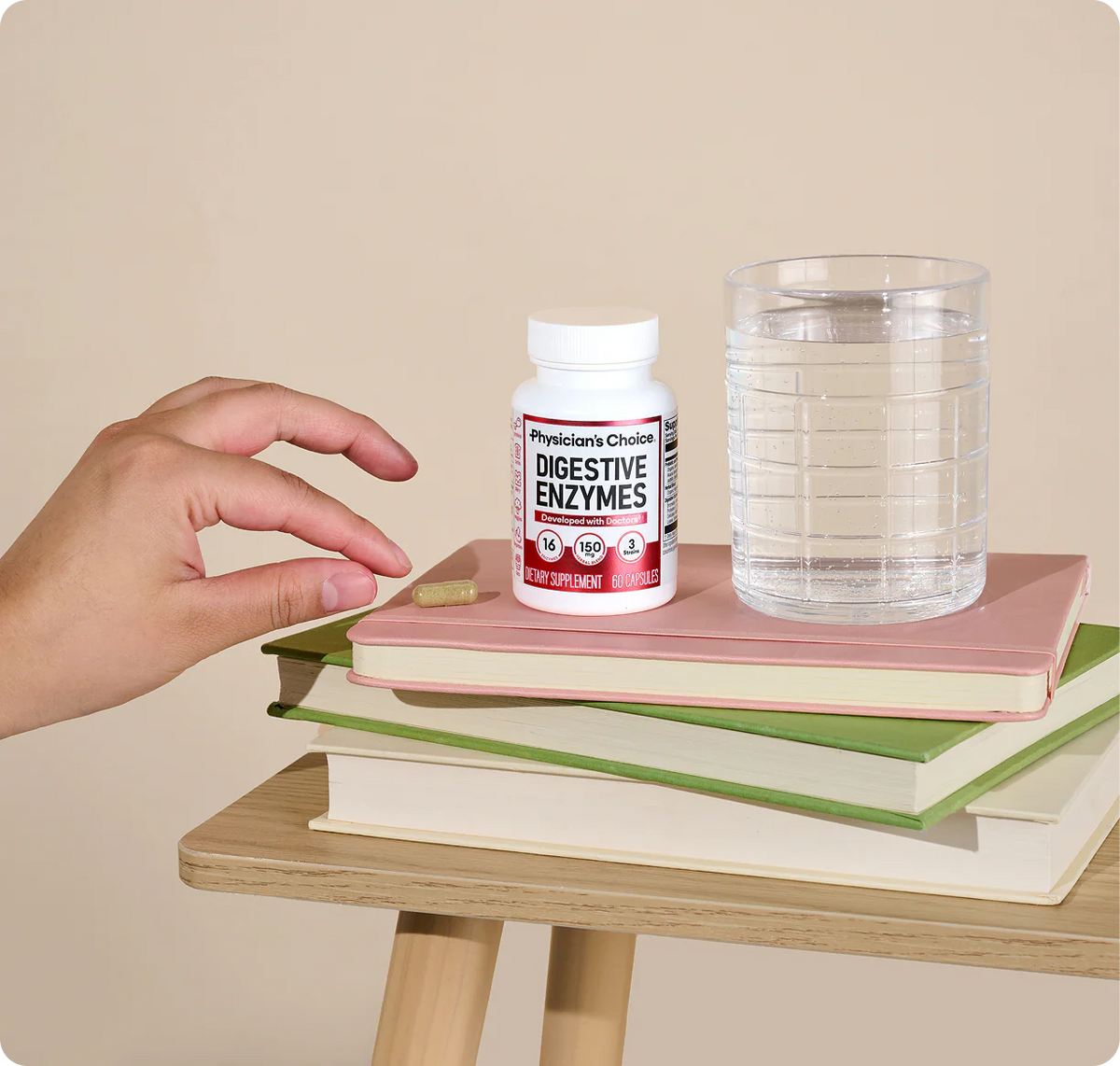 Frasco de enzimas digestivas con un vaso de agua sobre una mesa