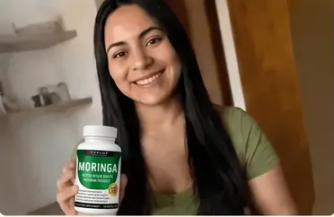 Gloria mostrando el frasco de moringa que compró