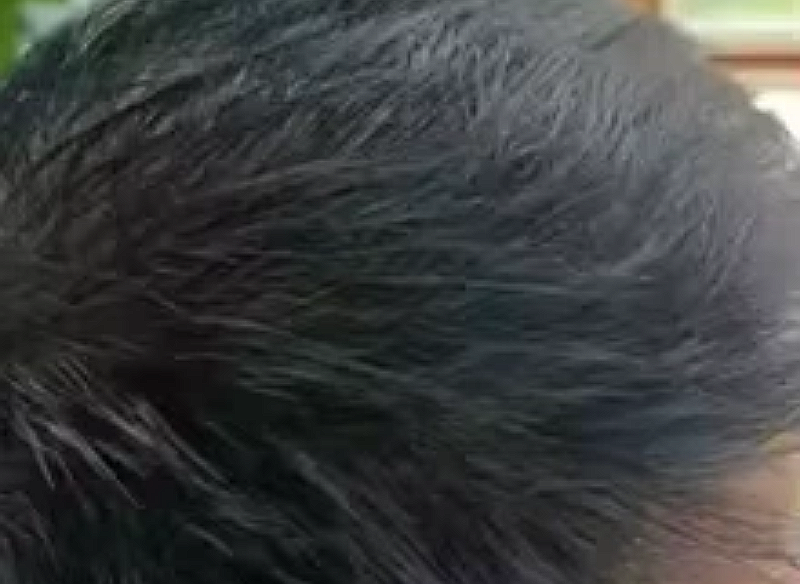 Cliente aplicándose el tinte en la patilla